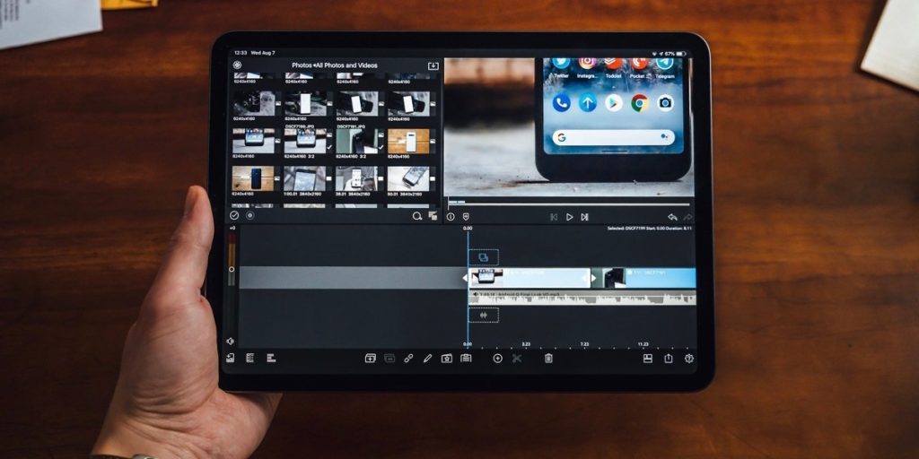 Man holding black tablet showing video editor