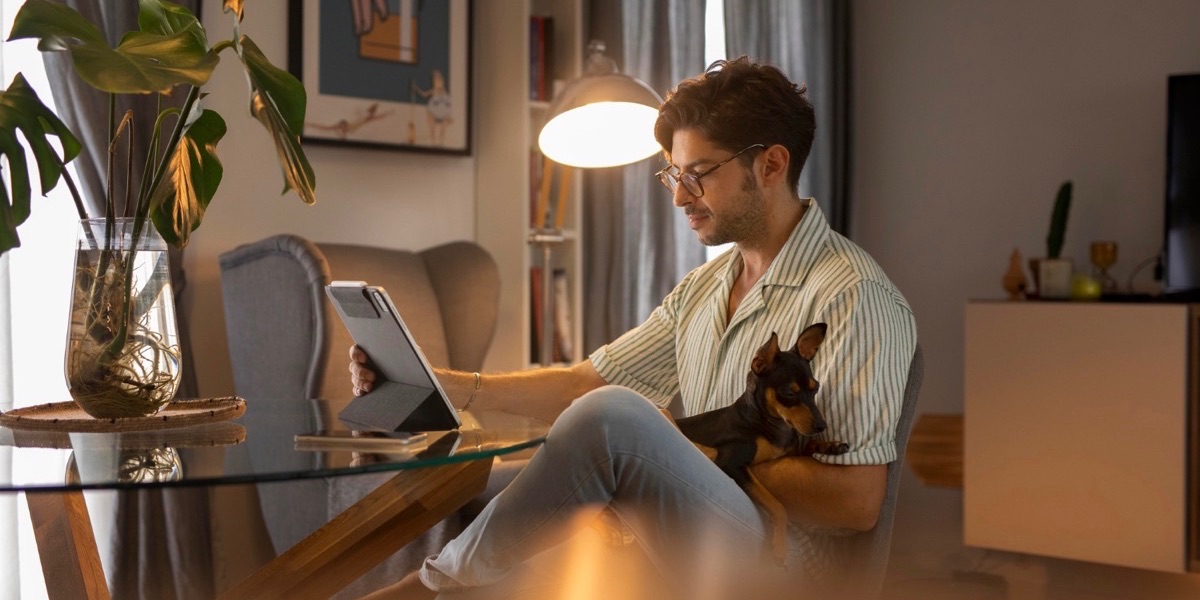Man working remotely from home with pet dog